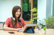 © THANANIT - Asian business woman using technology tablet with keyboard and headphone for working from home in outdoor home and garden, startups and business owner, social distance and self responsibility