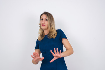 Beautiful brunette girl over isolated background afraid and terrified with fear, and disgusted expression stop gesture with both hands saying: Stay there. Panic concept