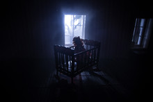 Old Creepy Eerie Baby Crib Near Window In Dark Room. Scary Baby Silhouette In Dark. A Realistic Dollhouse Living Room With Furniture And Window At Night