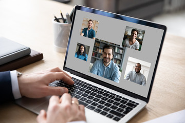 Wall Mural - Close up of businessman use modern laptop have webcam conference or briefing with diverse colleagues, make employee talk brainstorm on video call on computer with coworkers or team, online meeting