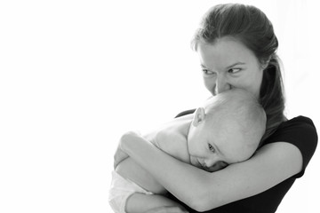 Black and white close portrait of young woman holding little baby in hands. Family love, tenderness and sincerity