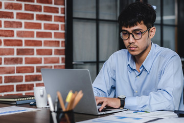 Wall Mural - asian businessman woking with laptop and paper work on desk  at office.digital workflow online business lifestyle concept.