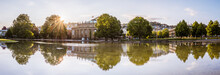 Panoramic View Of Stuttgart Opera House ("Opernhaus"), Reflections Of Trees In Lake, Warm Spring Morning