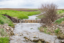 Water Flowing In Farm Field Waterway After Heavy Rain And Storms Caused Flooding. Concept Of Soil Erosion, Water Runoff Control And Management