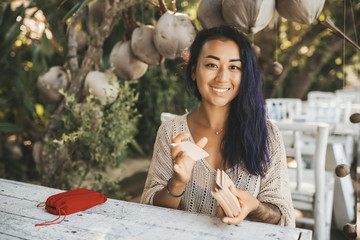 Wall Mural - Woman is reading Tarot cards sitting at the table outdoors