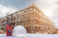 Helmet In Construction Site And Construction Site Background Safety First Concept, Walkie Talkie And Helmet Construction Site