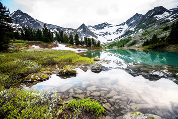 Sticker - Green lake between mountains in cloudy day