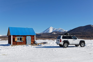 Small house and a car in a mongolian winter landscape