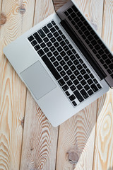 Poster - Top view of laptop on loft-style table in sunny day. Coworking or working at home concept image.