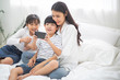 © winnievinzence - Happy family watch movie on smartphone. mother cuddle son and daughter video chat with friend or family for social distancing. stay home during Coronavirus or COVID19. new normal lifestyle insurance
