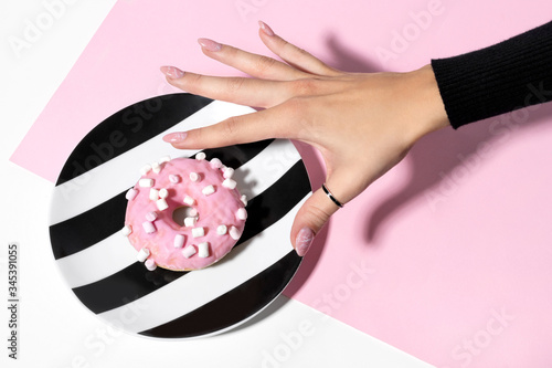 Female hand with trendy marble manicure holding donut Billede på lærred