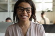 © fizkes - Close up headshot portrait picture of happy african american businesswoman with glasses. Smiling confident young diverse woman manager looking at camera on workplace background in office.