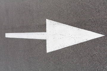 The pointing arrow on the asphalt is painted with white paint. Pointer to the right.