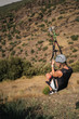 © ManuPadilla - Woman hanging on a rope-way. Zip line is an exciting adventure activity. Tourists ride on the Zip line through the mountain.