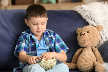 Poster - Cute little boy eating popcorn and watching TV at home