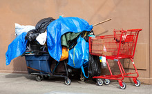 Homeless Person's Belongings Piled On Carts Covered With Plastic Tarps.