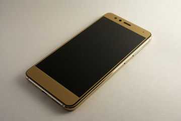 Wall Mural - Golden smartphone, phone on a white background, modern technology.