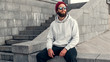 © San4ezz007 - City portrait of handsome hipster guy with beard wearing gray blank hoodie or hoody with space for your logo or design. Mockup for print