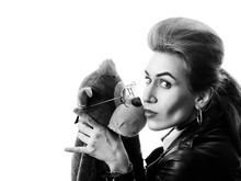 Beautiful Girl In Black Leather Jacket Holds Hands Soft Toy Monkey In Glasses On A White Background. Black And White Photography