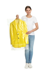 Canvas Print - Young woman holding hanger with jacket in plastic bag on white background. Dry-cleaning service