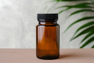 Wall Mural - blank medical bottle mockup for pills. transparent dark bottle of amber glass with green plant. herb
