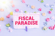 Text sign showing Fiscal Paradise. Business photo showcasing The waste of public money is a great concern topic Colored crumpled papers empty reminder blue floor background clothespin