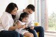 © xreflex - Happy Asian family using technologies for fun. Father, mother and daughter looking at digital tablet on sofa in the home. Communication technology and lifestyle