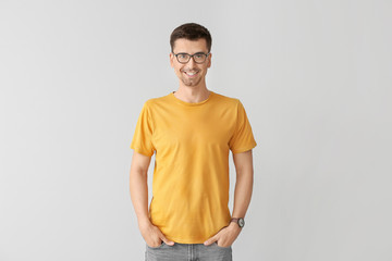 Wall Mural - Man in stylish t-shirt on grey background