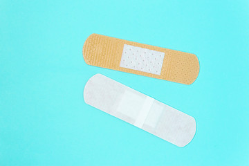 skin color medicine adhesive healing bandage layout on blue background. medical aid healing patch co