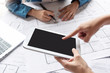 © eggeeggjiew - Architect Designer hands brainstorming and working with colleague and creative team on blueprint plans and using digital tablet for design building and interior projects in meeting at office
