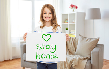 Poster - pandemic, quarantine and people concept - happy smiling girl holding handwritten stay home message on paper