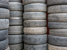 Used Car Tires Stacked In Piles.Worn Out Rubber Tires.