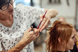 © astrosystem - Hair dresser cutting hair in a saloon.