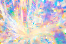Abstract Radiant Festive Merry Holiday Backdrop Texture Image Of Holographic Iridescent Metallic Foil Ribbon Decoration With Warm Bright Glow And Sparkling Crystal Ice Reflections And Bokeh Light