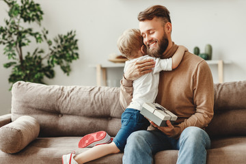 Wall Mural - little boy congratulating father with gift.