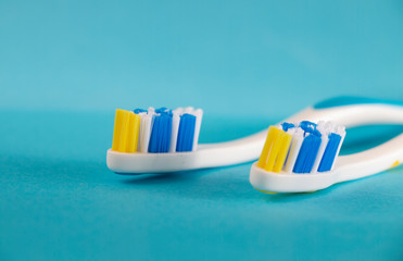 two beautiful toothbrushes with blue and yellow bristles on a blue background