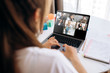 © Kateryna - Business team working from home in a video conference. The back view of a girl who communicates online by video conference with her work colleagues using a laptop. Zoom conference