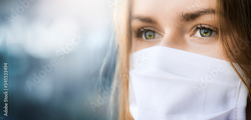 Fotografía Epidemic Corona Virus masked girl on the blur background of the city