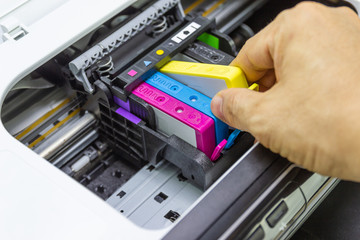 Technicians are install setup the ink cartridge of a inkjet printer the device of office automate for printing