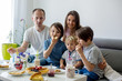 © Tomsickova - Happy family, having pancakes for breakfast, eating in living room, talking and lauging