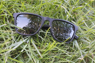 plastic body black sunglasses in grass a close view 