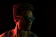 © IndiaPix - Muscular man wearing sunglasses standing in front of a dark background.