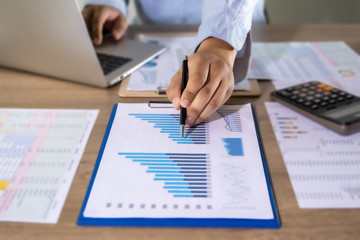 Wall Mural - Man Usingcalculator with money stack Financial Report- Business Accounting Concept accounting money with statistics graphs
