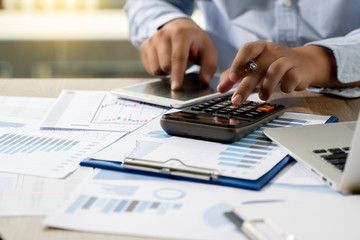 Wall Mural - Financial Report- Business Accounting money stack Concept Business Man Using Calculator graph discussion and analysis data charts and graphs