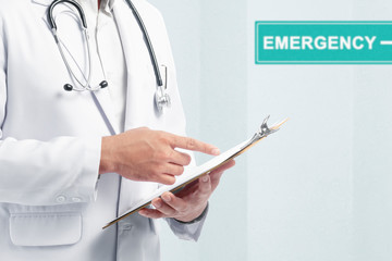 Doctor man with stethoscope holding a clipboard on the emergency room