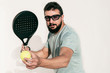 © FotoAndalucia - Paddle tennis man portrait serving ball on white wall in sun light