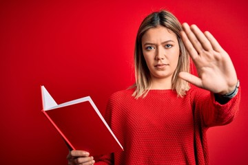 Sticker - Young beautiful woman reading book standing over isolated red background with open hand doing stop sign with serious and confident expression, defense gesture