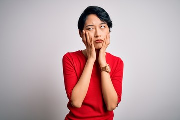 Poster - Young beautiful asian girl wearing casual red t-shirt standing over isolated white background Tired hands covering face, depression and sadness, upset and irritated for problem