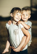 © Marina - older sister plays with brother in nature
