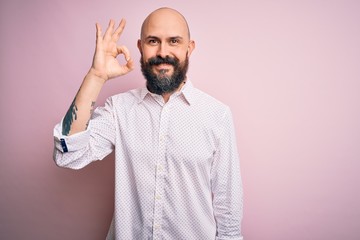 Poster - Handsome bald man with beard wearing elegant shirt over isolated pink background smiling positive doing ok sign with hand and fingers. Successful expression.